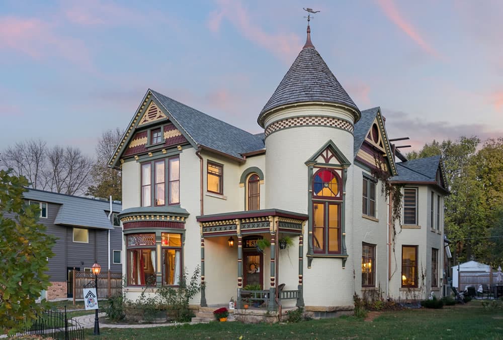 White stucco 2 story house, stained glass windows and turret