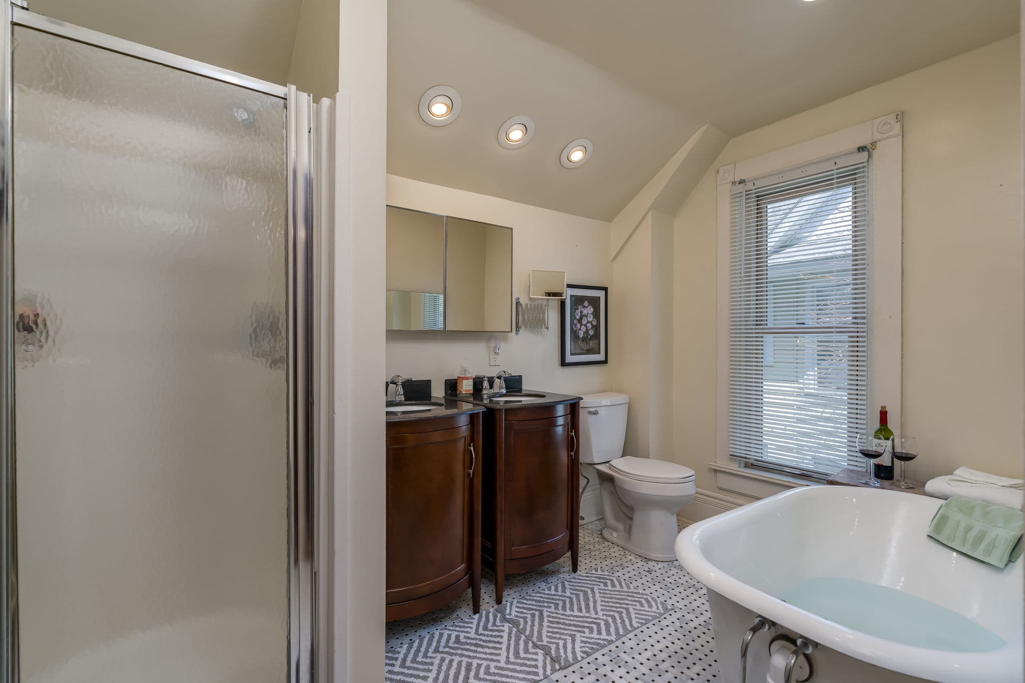A bright, modern bathroom featuring a shower, freestanding tub, and stylish cabinetry.