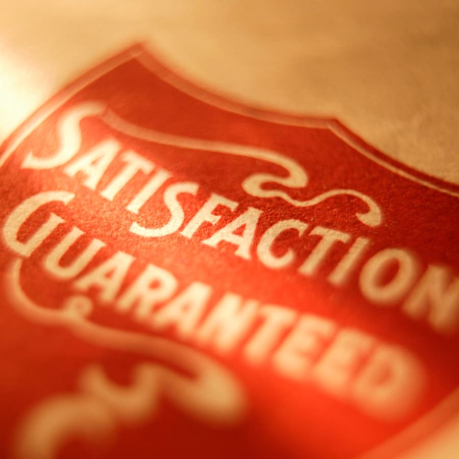 A close-up of a red badge featuring the words "Satisfaction Guaranteed."