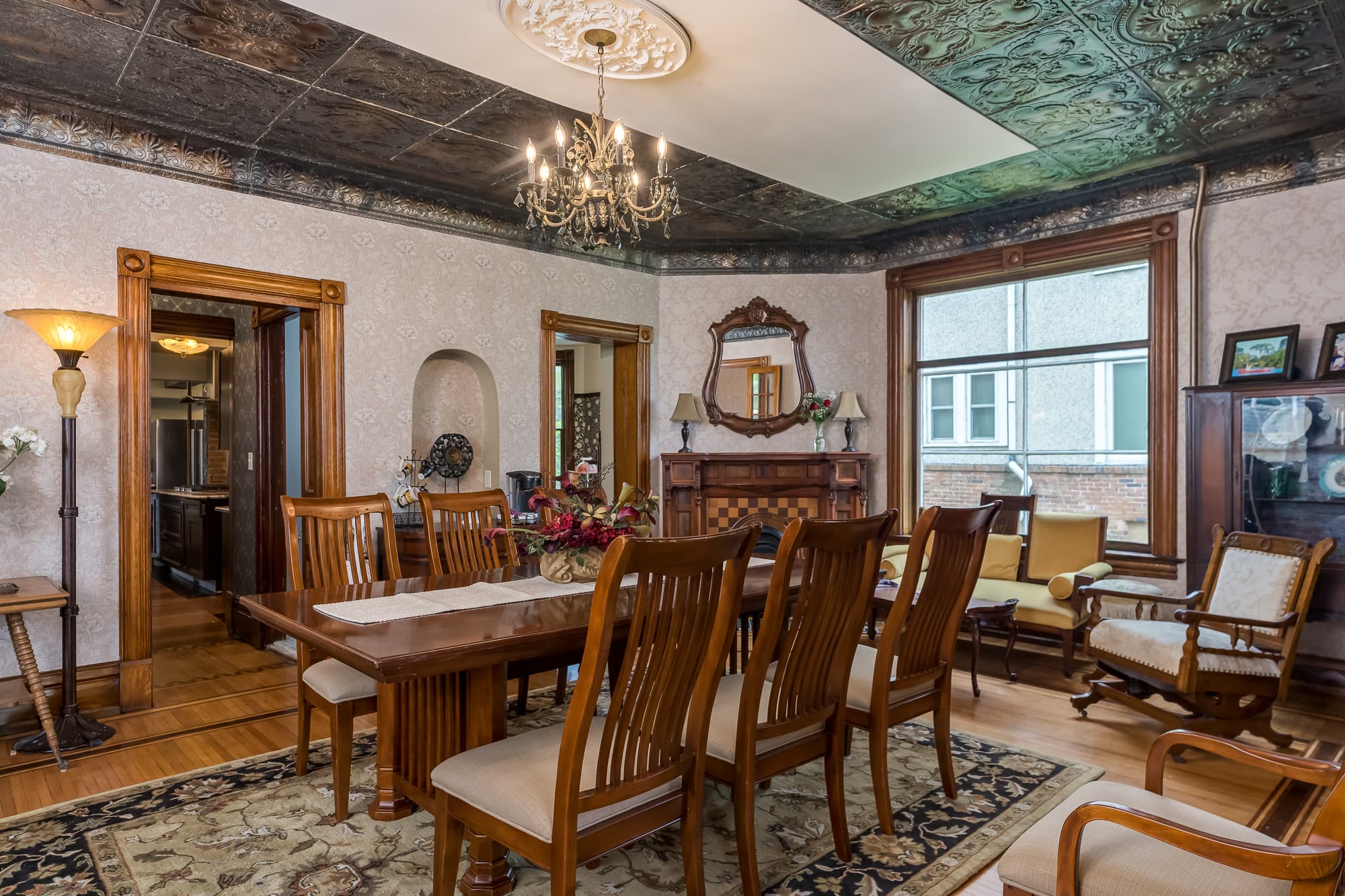 A cozy dining room featuring a wooden table surrounded by chairs, decorative molding, and a chandelier.